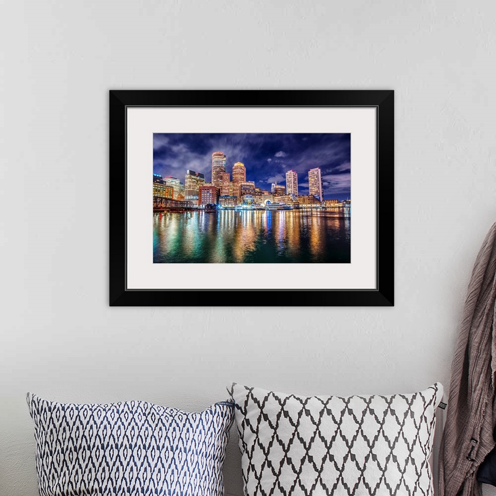 A bohemian room featuring The lights of downtown Boston reflect upon Massachusetts Bay.