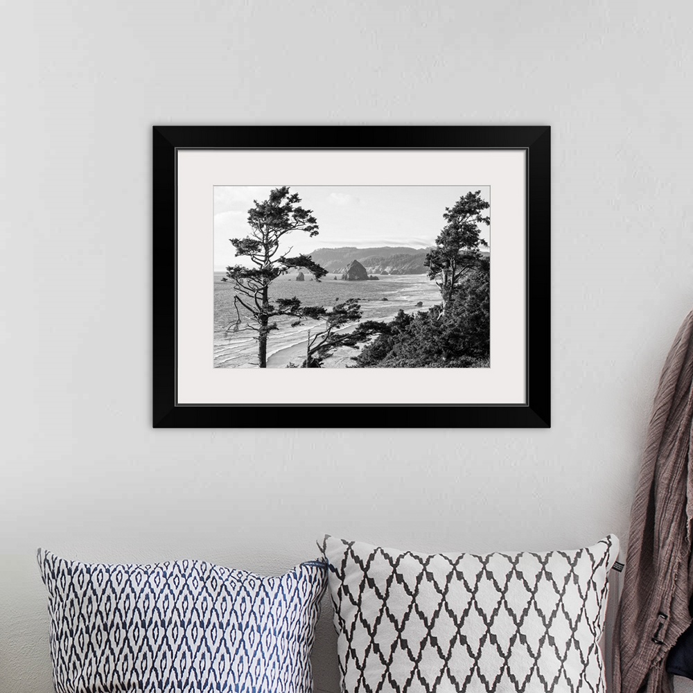 A bohemian room featuring Black and white landscape photograph of Cannon Beach through the trees with Haystack Rock in the ...