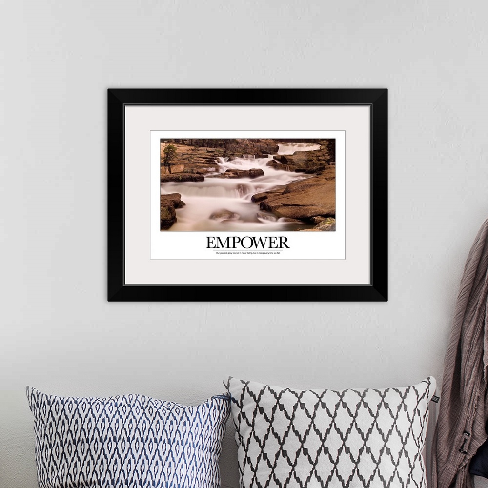 A bohemian room featuring Motivational poster depicting a stream flowing through rocks with the text, "Empower: Our greates...