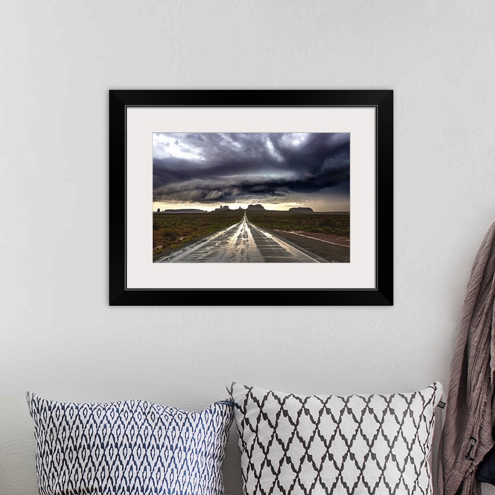 A bohemian room featuring Photograph of Monument Valley with dramatic clouds above taken from a wet road after a storm.