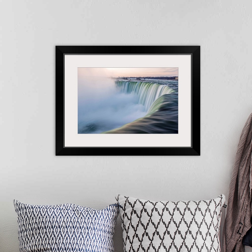 A bohemian room featuring Water cascades down at Horseshoe Falls while dramatic mist ascents to meet the rising sun.