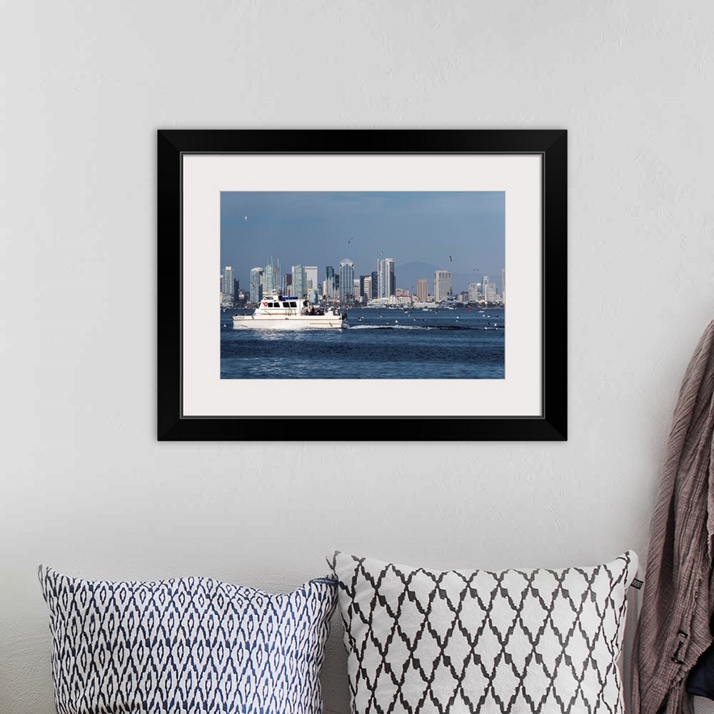 A bohemian room featuring Photograph of a charter fishing boat on the Pacific Ocean with seagulls flying around it and the ...