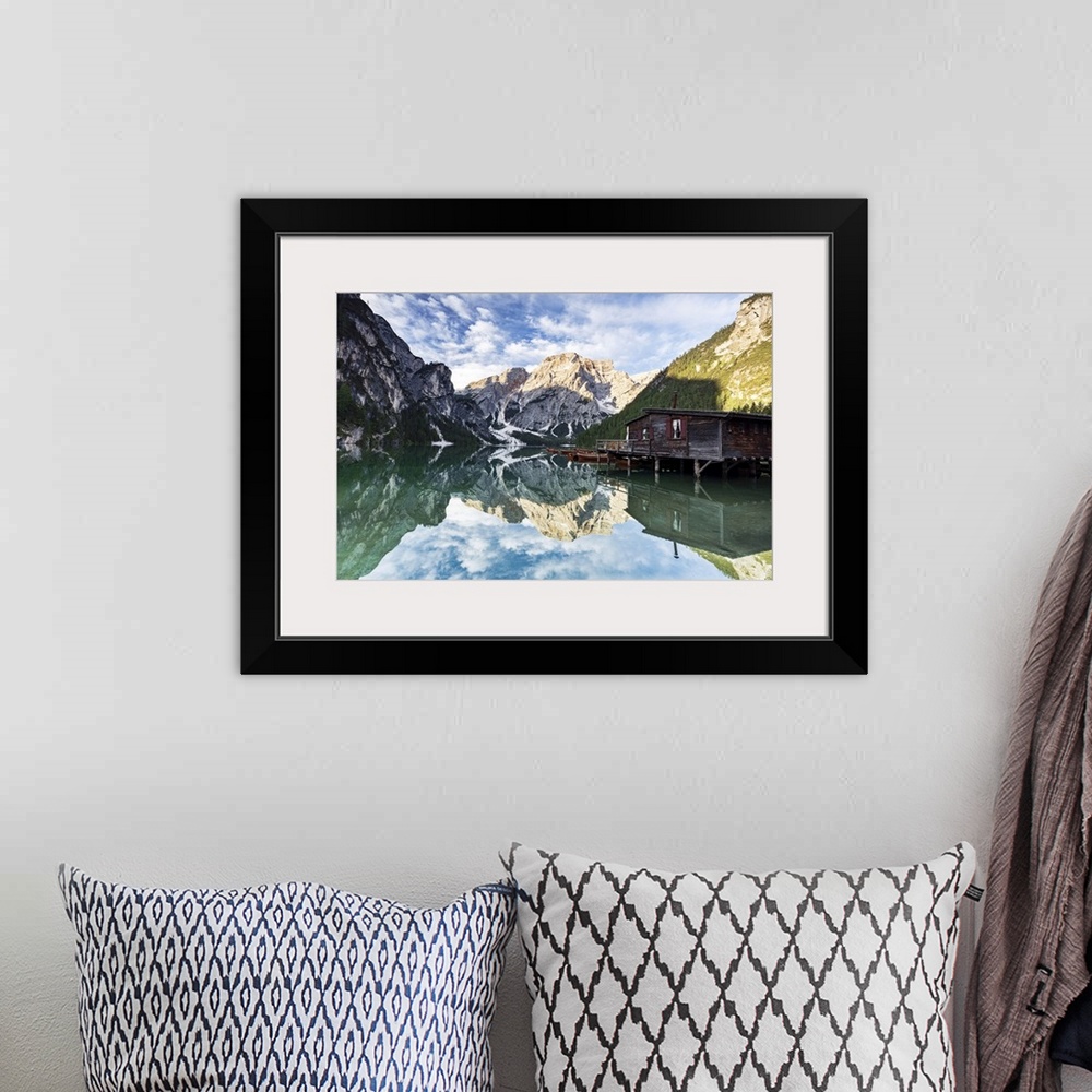 A bohemian room featuring Lake Braies (Pragser Wildsee) at sunrise with Croda del Becco mountain reflected in water, Dolomi...