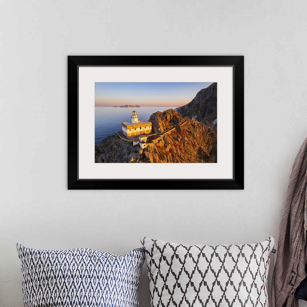 A bohemian room featuring Aerial view of Punta della Guardia lighthouse on top of a cliff on the island of Ponza, lit from ...