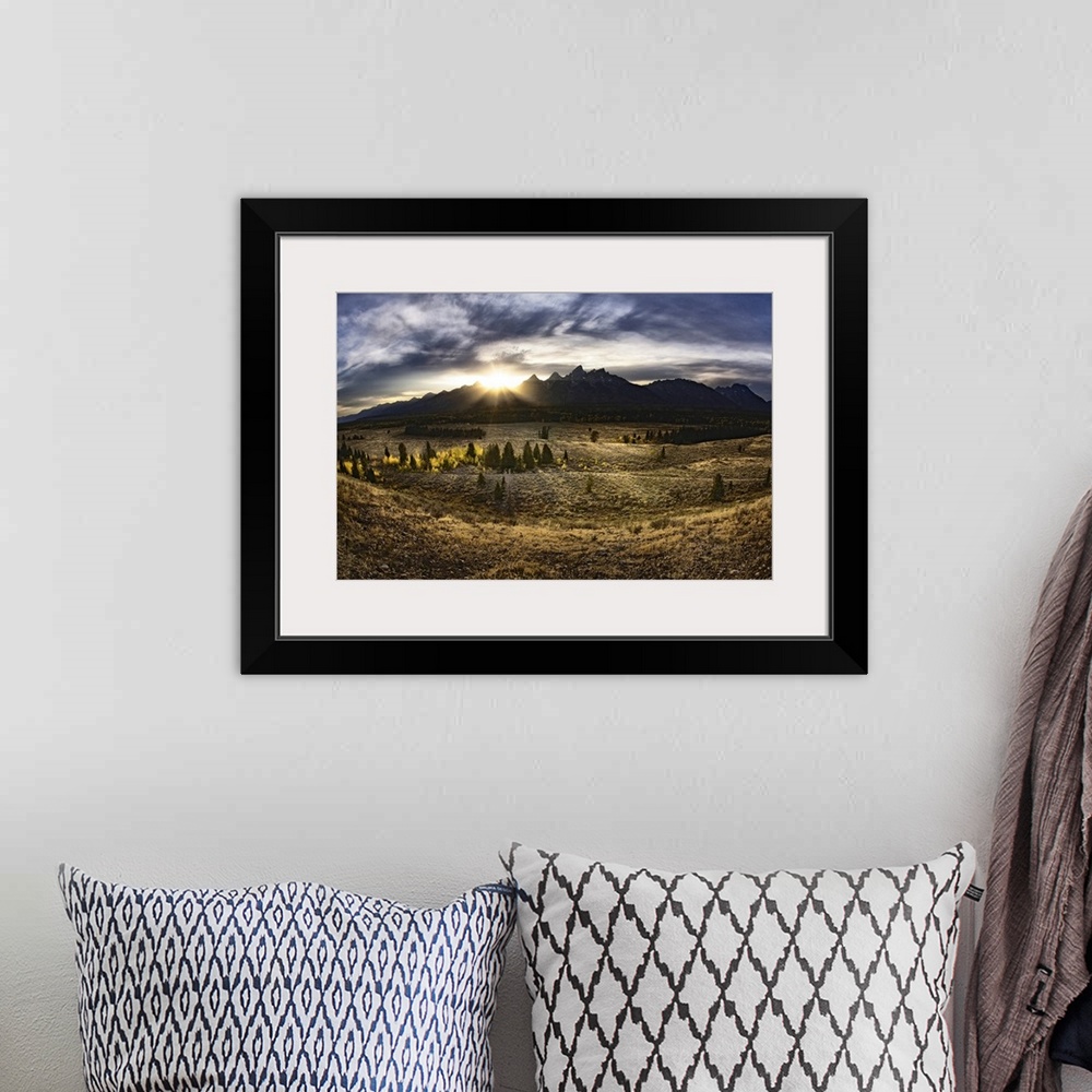 A bohemian room featuring Giant, landscape photograph of a vast field in Jackson Hole, Wyoming, the sun rising just above t...