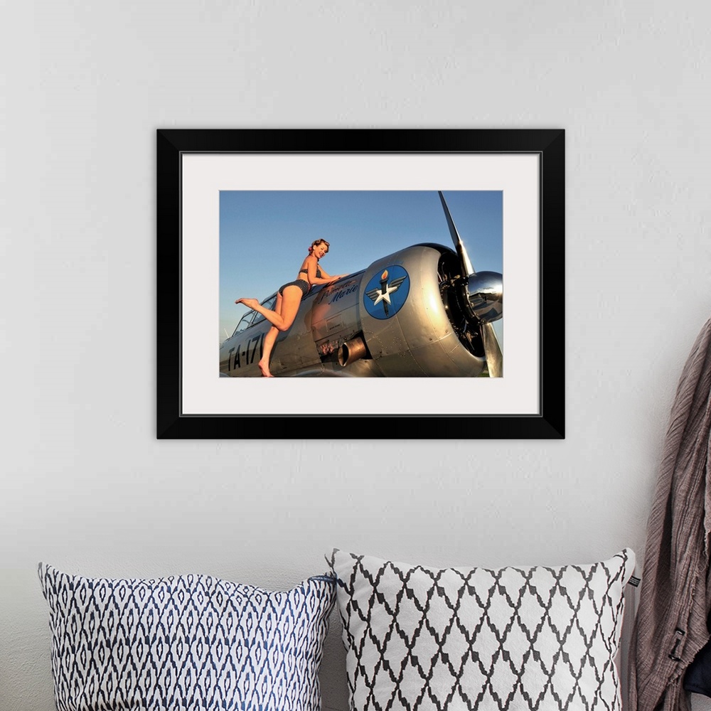 A bohemian room featuring 1940's style pin-up girl standing on the wing of a World War II T-6 Texan.