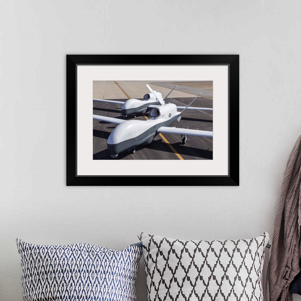 A bohemian room featuring May 21, 2013 - Two Northrop Grumman MQ-4C Triton unmanned aerial vehicles on the tarmac at a Nort...