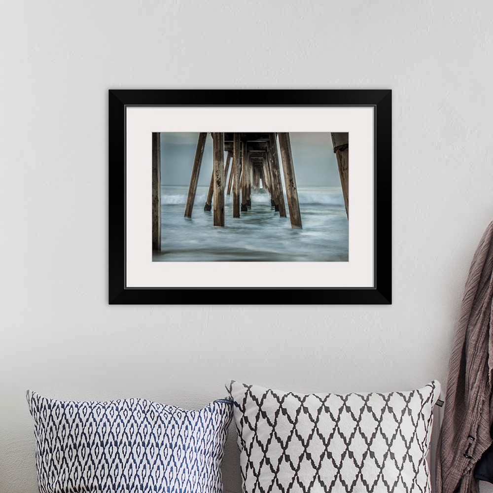 A bohemian room featuring View from below of a wooden pier stretching out into the ocean.