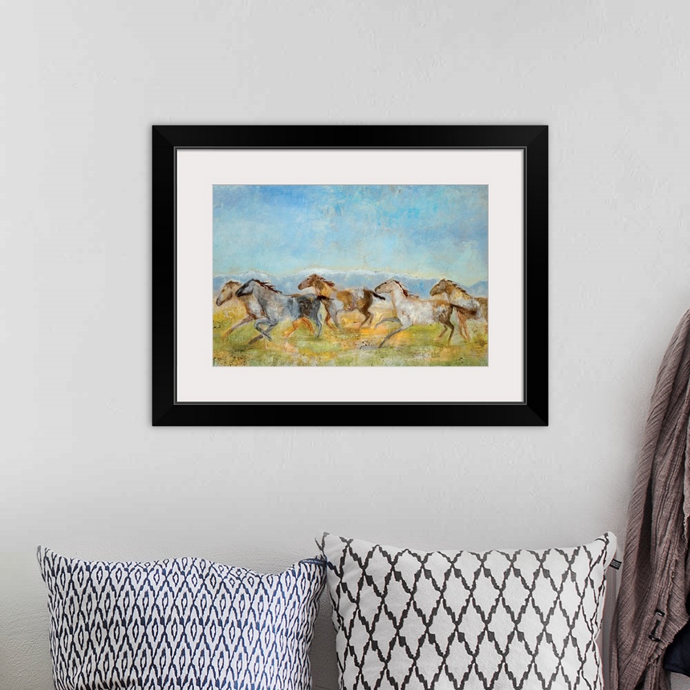 A bohemian room featuring A landscape painting of wild horses running across the plains; the horses have been painted with ...