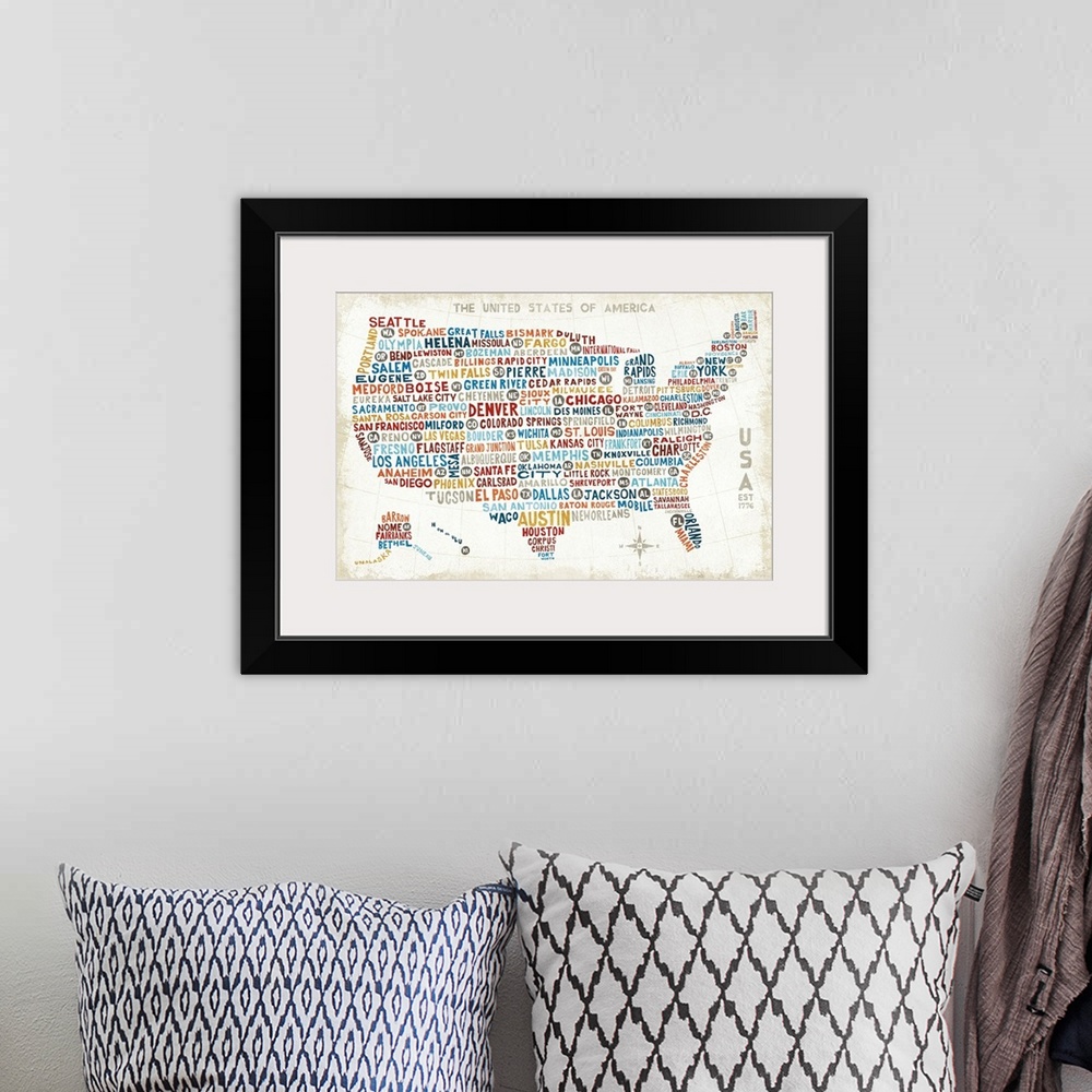 A bohemian room featuring A map of the United States with the names of large cities in colorful text.