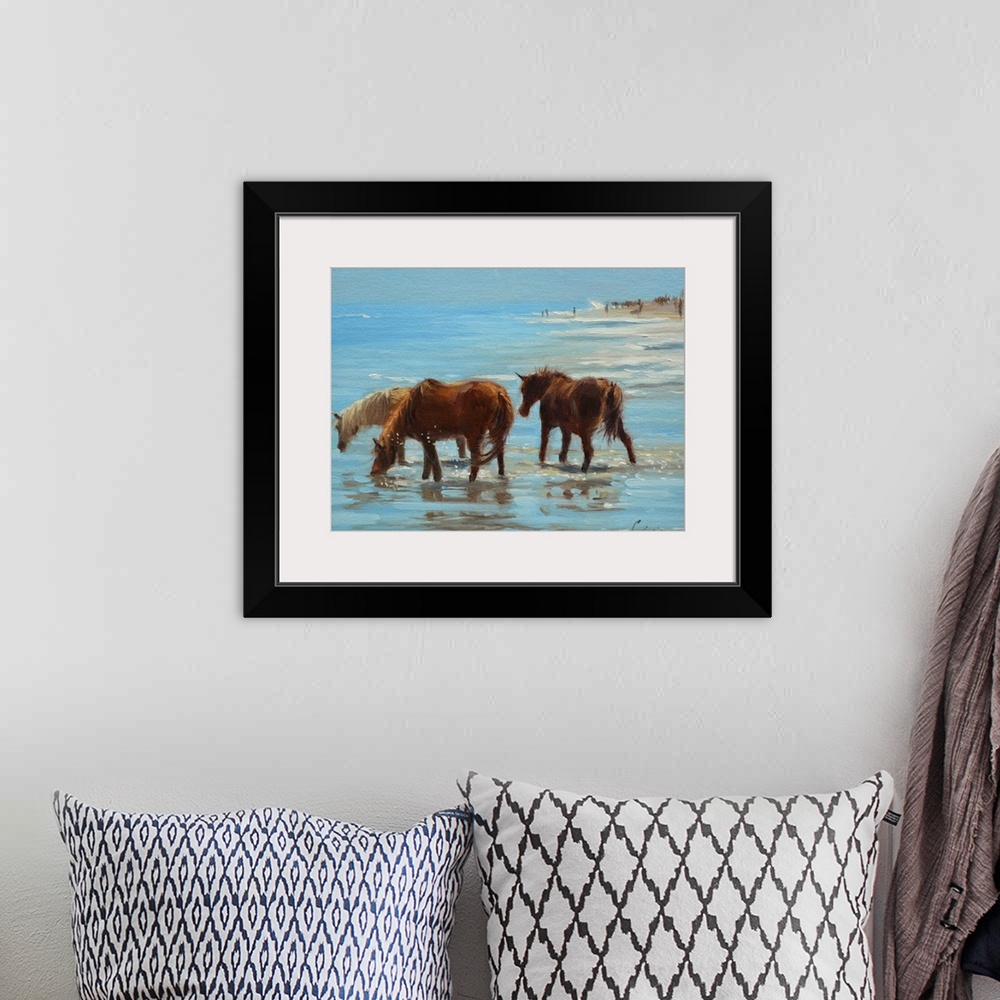 A bohemian room featuring A painting of horses on a beach wading through shallow water.