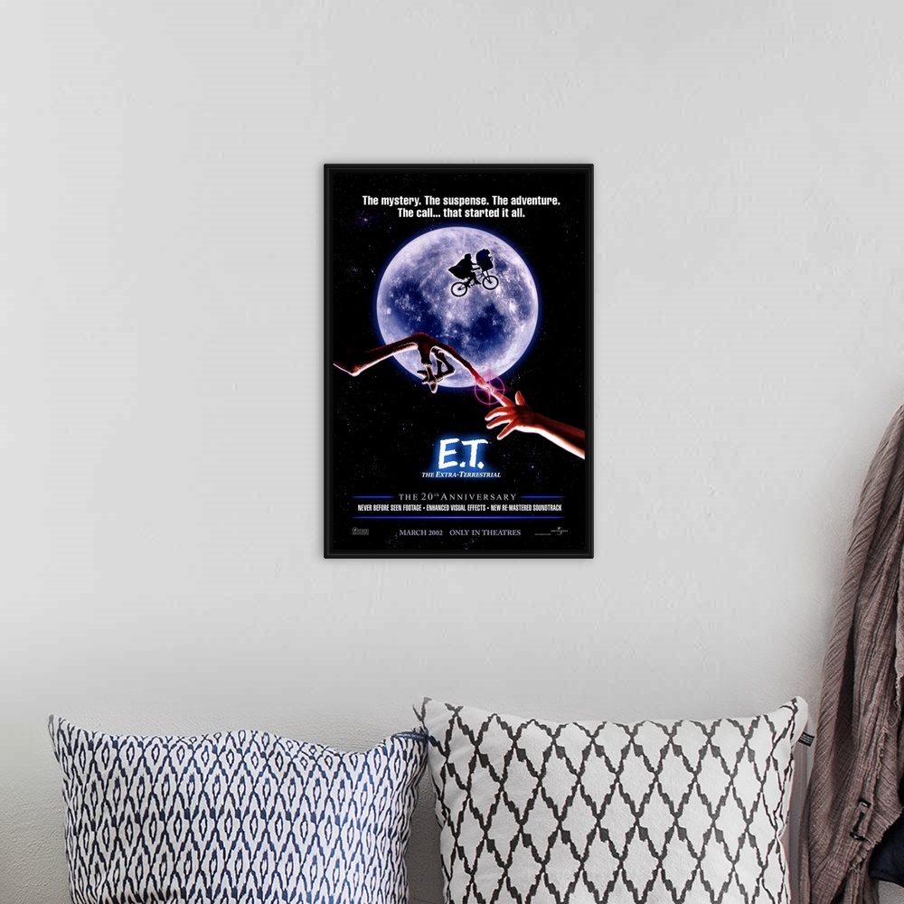 A bohemian room featuring A large vertical print of the 20th anniversary poster of E.T. It depicts the famous scene of the ...
