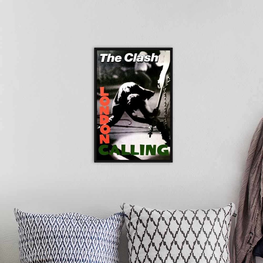 A bohemian room featuring Vertical, oversized black and white photograph of a band member of The Clash swinging a guitar to...