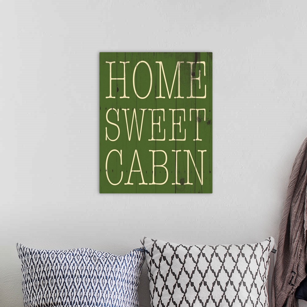 A bohemian room featuring Typographical artwork with "Home sweet cabin" in a thin rustic text.