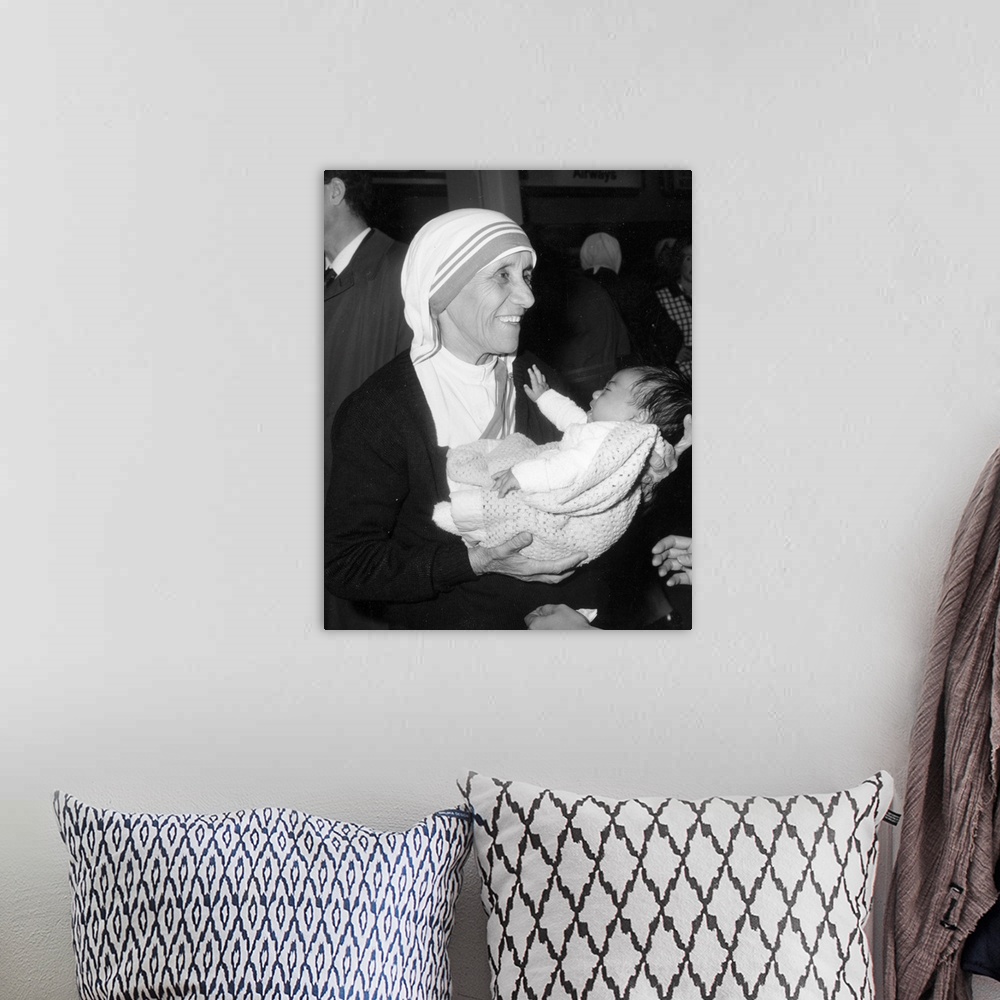 A bohemian room featuring Christian missionary Mother Teresa of Calcutta (1910 - 1997) holding a baby at Heathrow Airport, ...