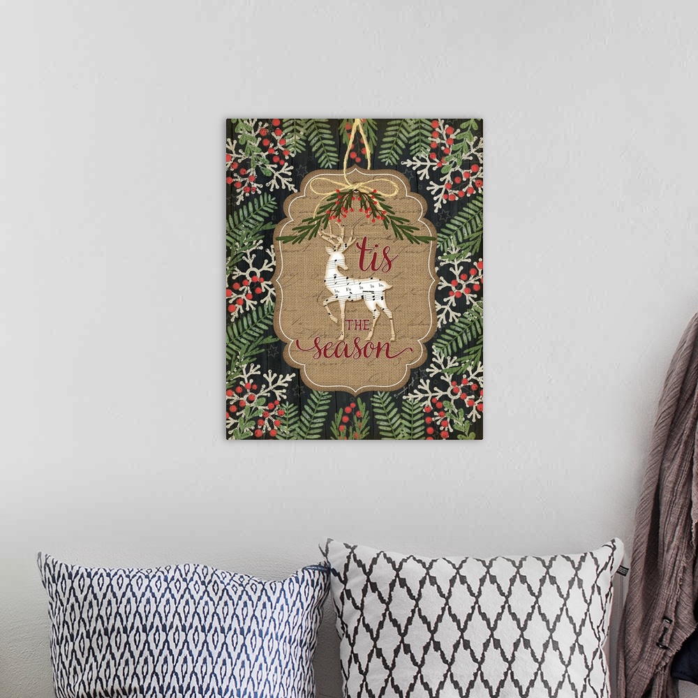 A bohemian room featuring Christmas decor featuring a deer cut out of sheets of music and the words, "'Tis the season" .
