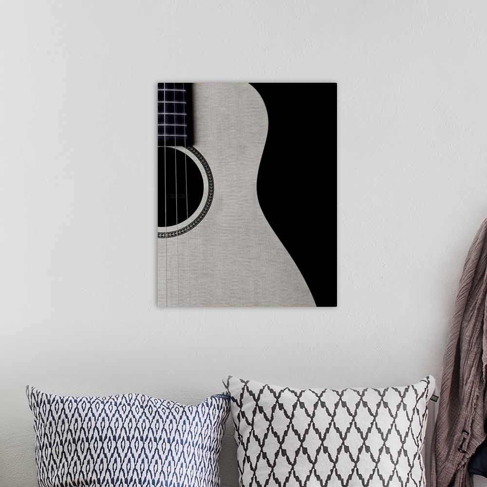 A bohemian room featuring Black and white photograph of half a guitar highlighting its curves.