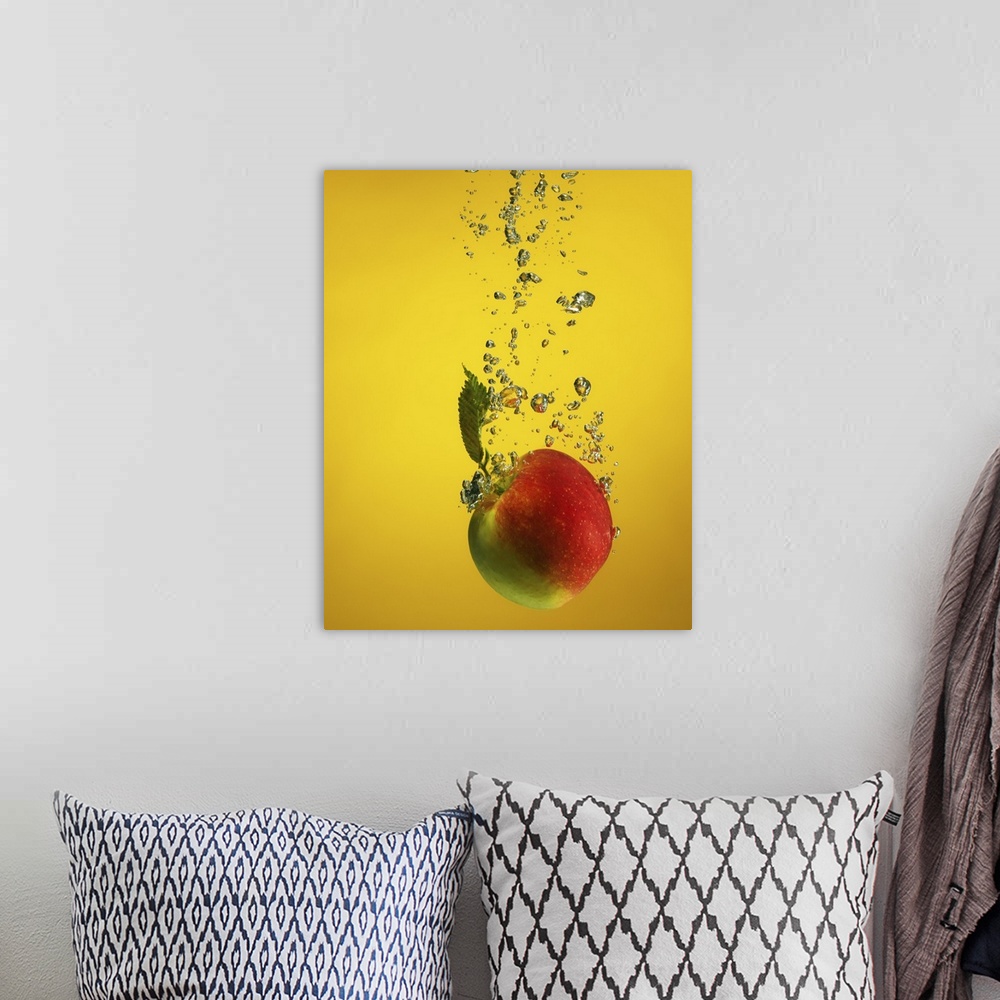 A bohemian room featuring An apple splashed into water, creating bubblessplash. on yellow backdrop