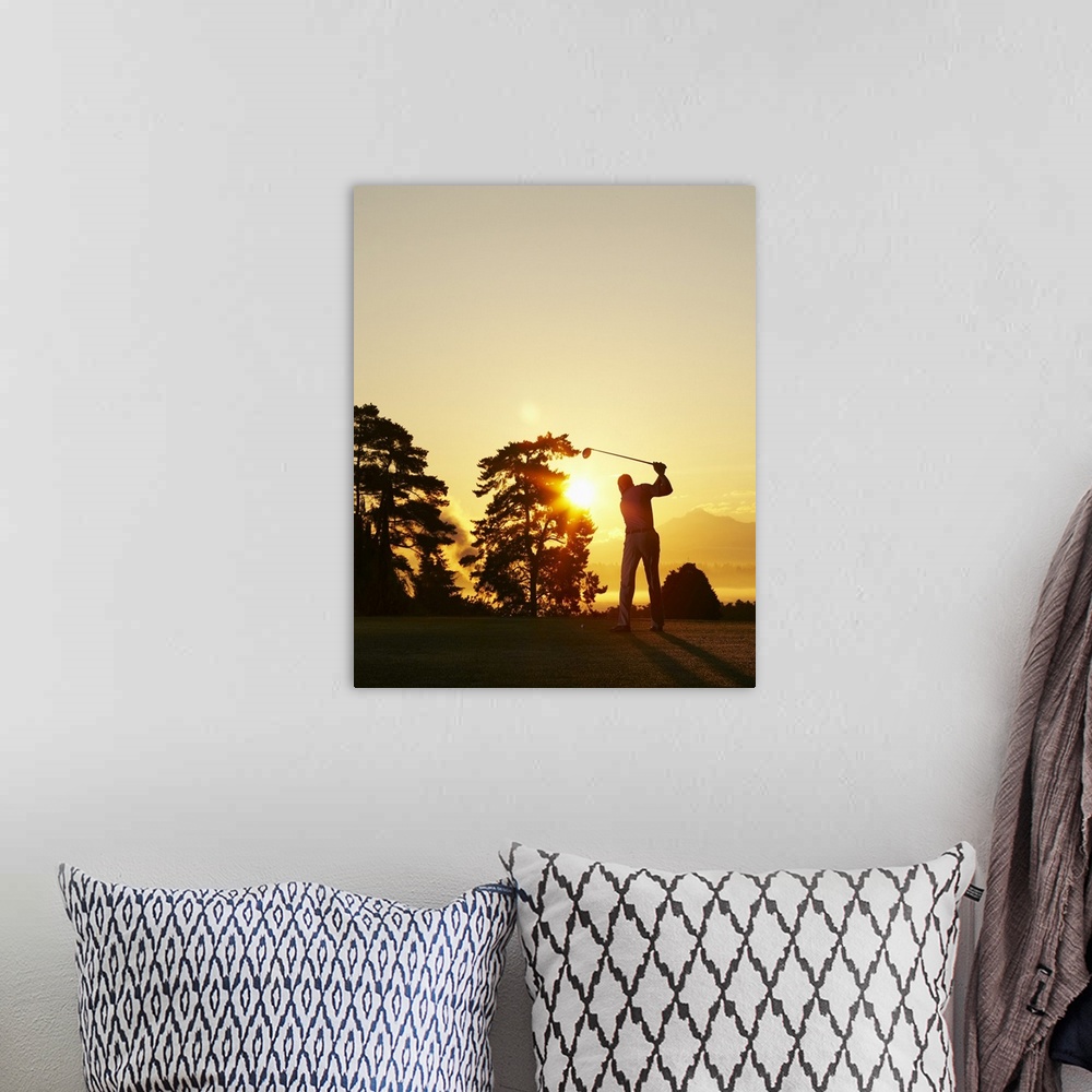 A bohemian room featuring Big, vertical photograph of the setting sun behind trees on a golf course.  The silhouette of a g...