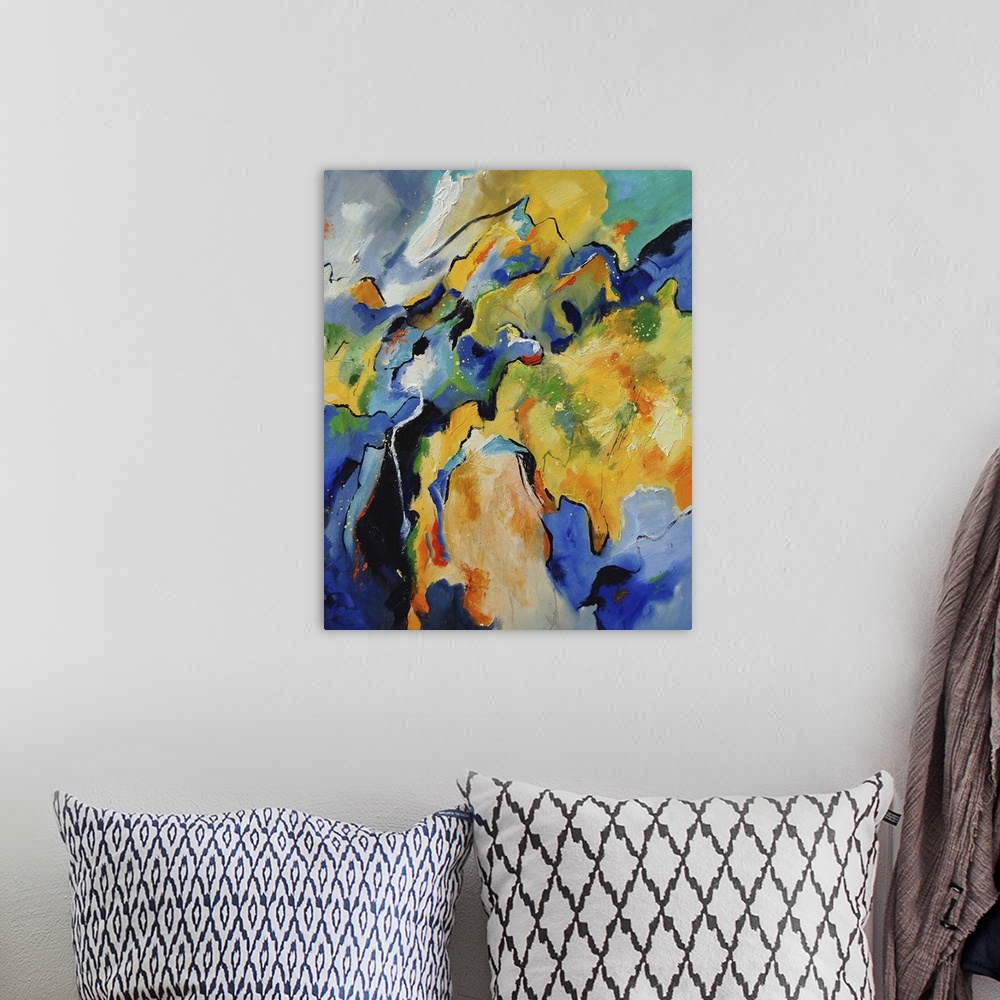 A bohemian room featuring A vertical abstract painting with deep colors of blue, green and yellow.
