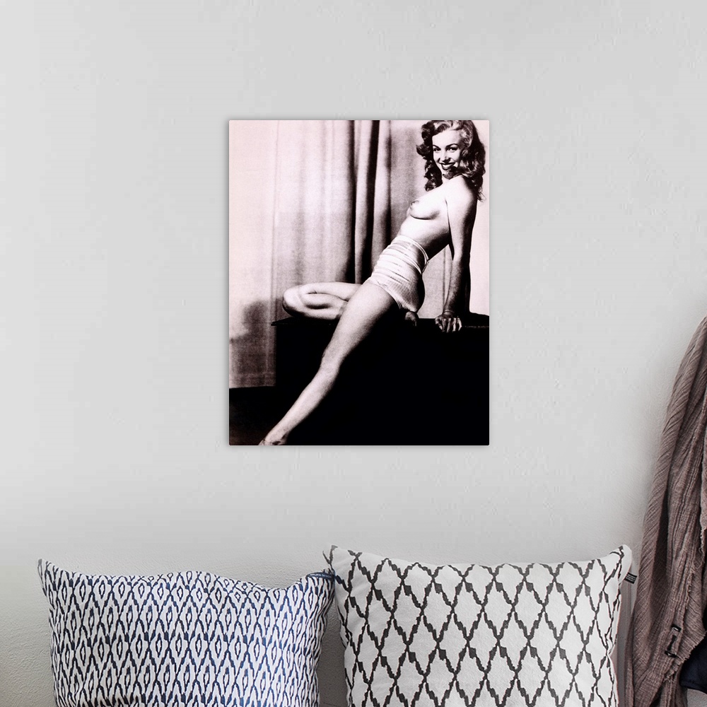 A bohemian room featuring Boudoir photo of Marilyn Monroe topless and leaning back on a stand in front of a curtain, smilin...