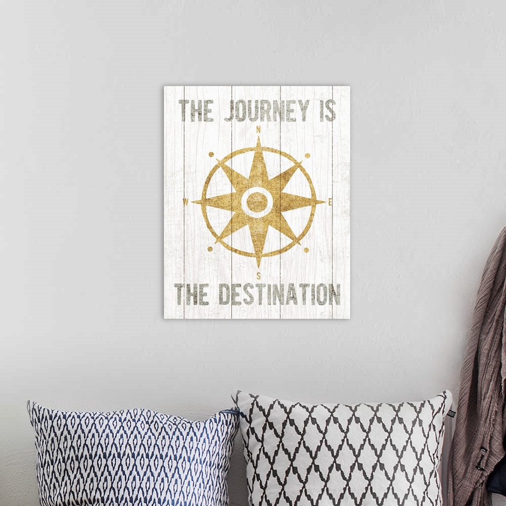 A bohemian room featuring Metallic gold rose compass and the phrase "The Journey Is The Destination" on a white wood panele...
