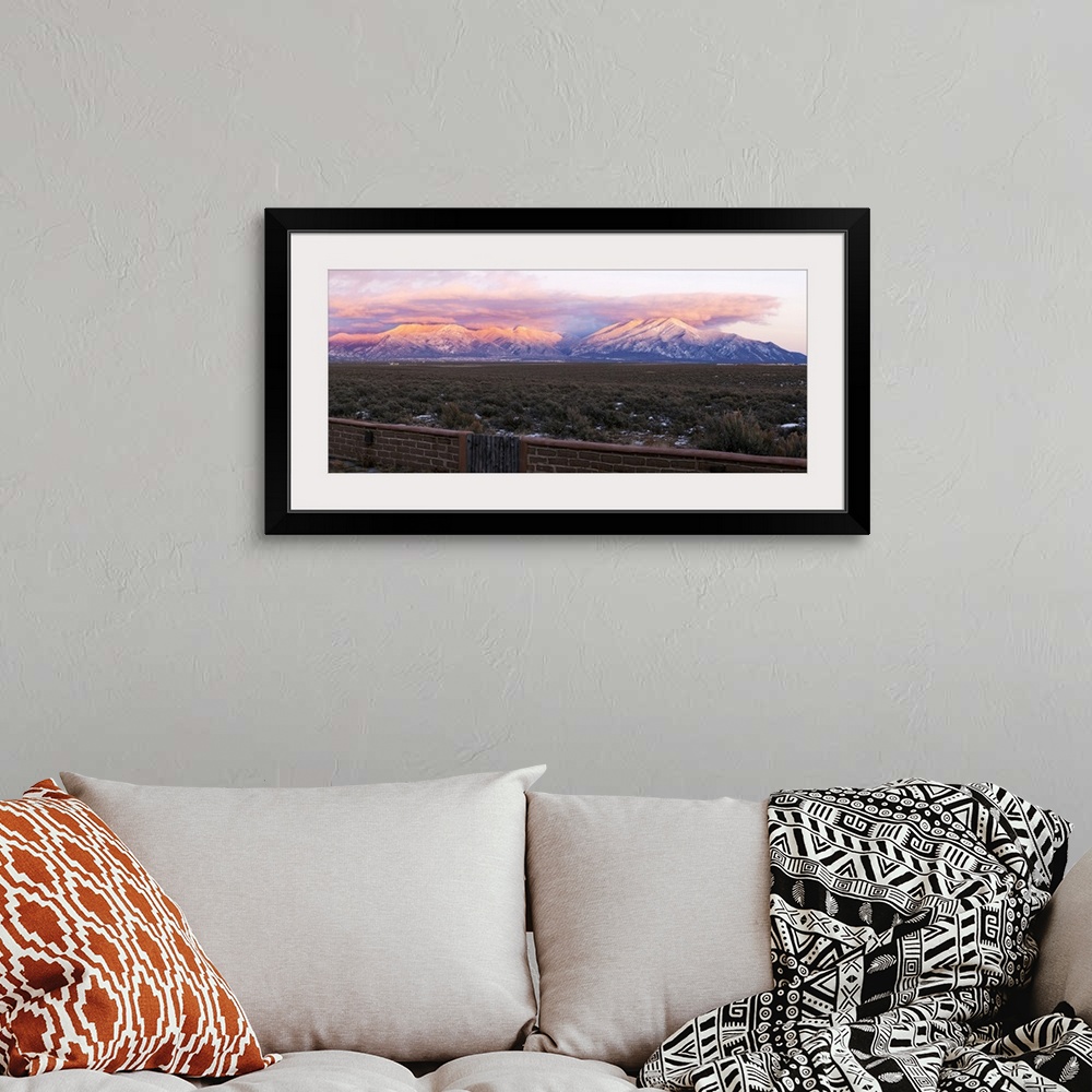 A bohemian room featuring Mountain range viewed from an adobe brick wall and Sangre De Cristo Mountains, New Mexico, USA.