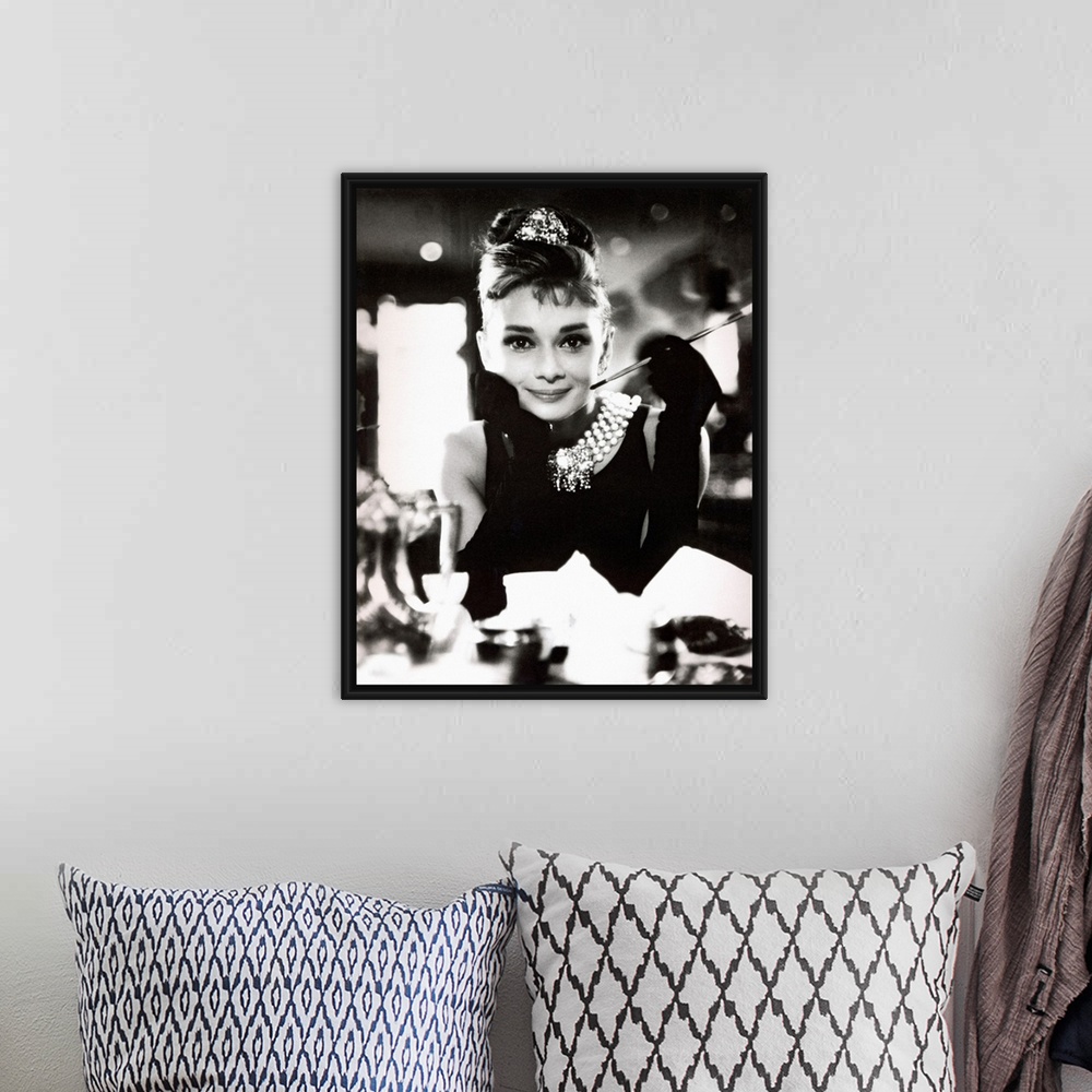 A bohemian room featuring Classic iconic photograph of Audrey Hepburn sitting at a table holding a cigarettte and smiling.