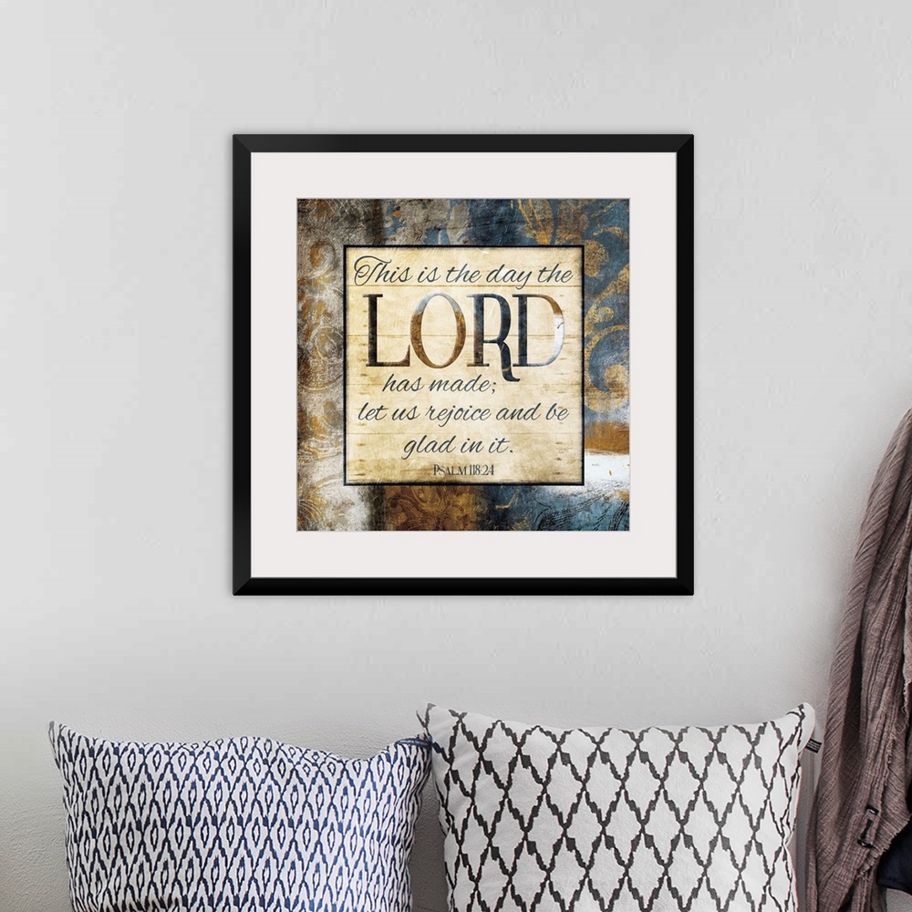 A bohemian room featuring Typography art of the Bible verse Psalm 118:24 framed with classic style gold and blue flourishes.