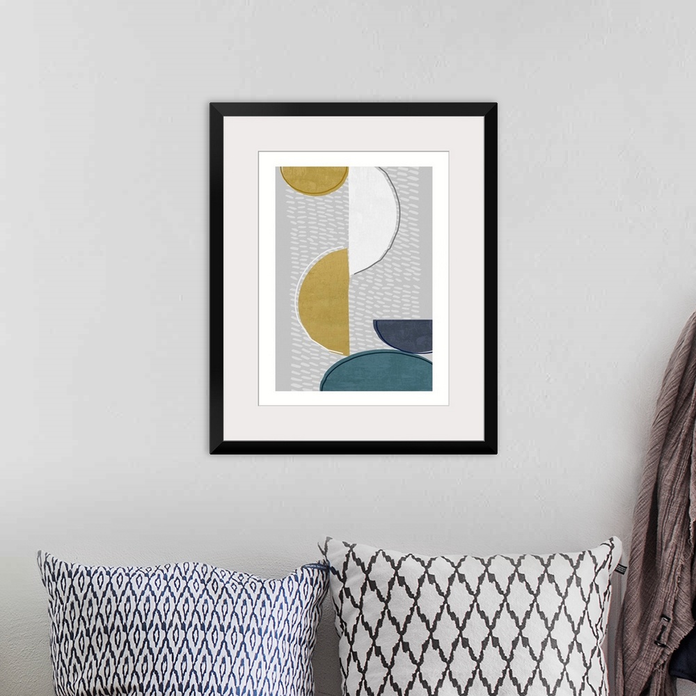 A bohemian room featuring Midcentury style abstract art of semi-circle shapes in blue, gold, and white on grey.