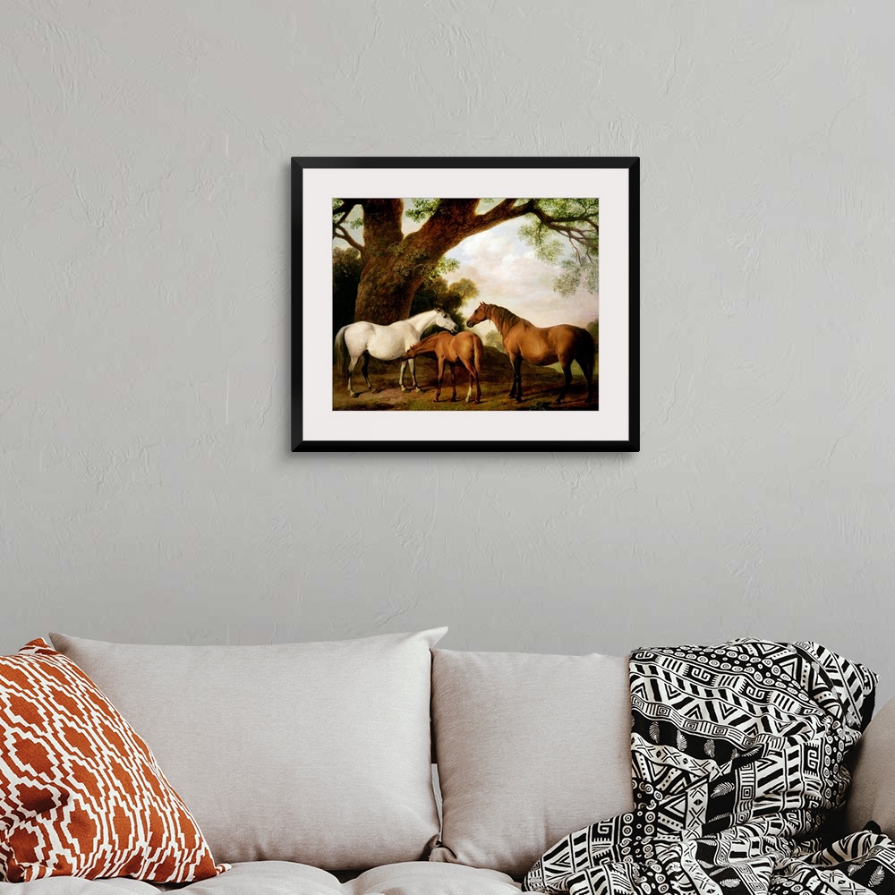 A bohemian room featuring Giant classic art focuses on three horses standing beneath a very large tree on the edge of a for...
