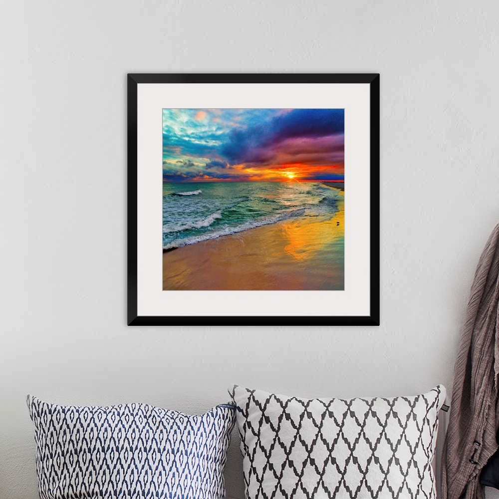 A bohemian room featuring A square image of the sun descending over the ocean amid bright, technicolor clouds.