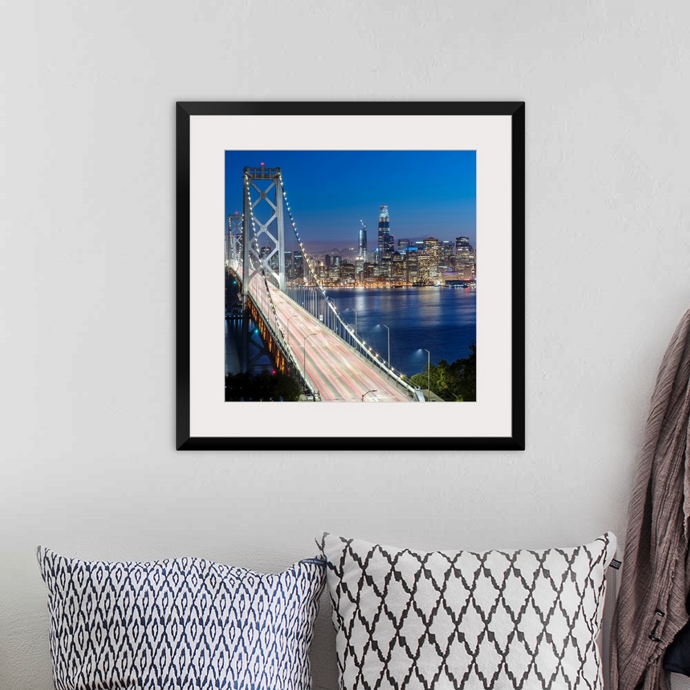 A bohemian room featuring Square photograph of the Bay Bridge at dusk with downtown San Francisco lit up in the background.