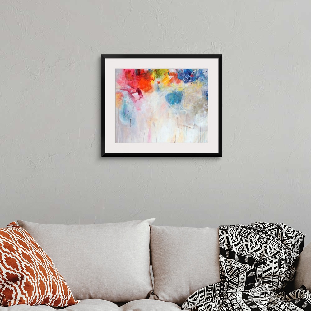 A bohemian room featuring Contemporary abstract painting of bright multi-colored forms overtop a neutral background.