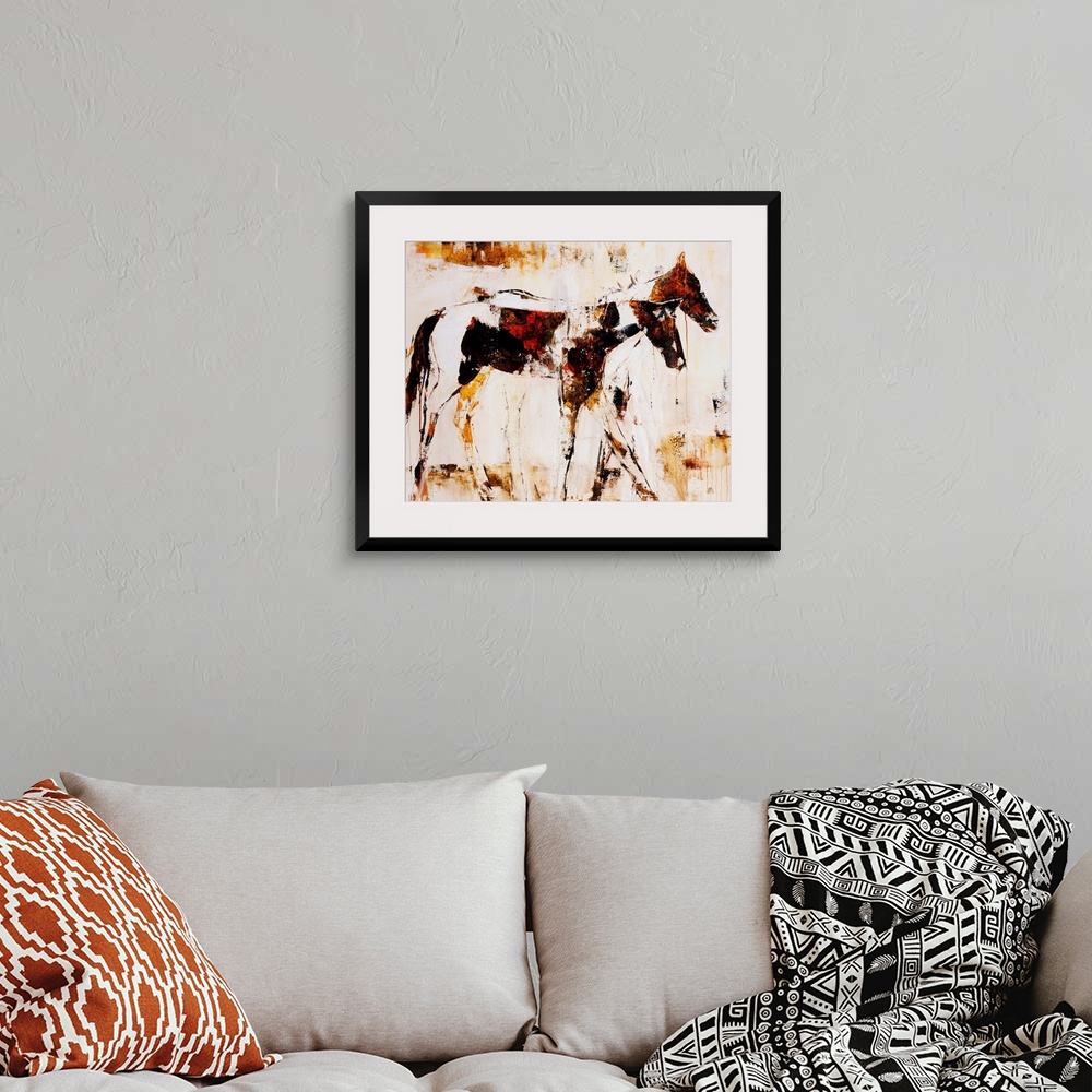 A bohemian room featuring Earth-toned portrait of two horsed standing side by side.