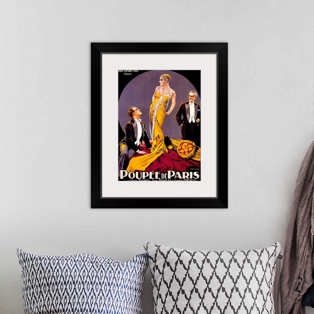 A bohemian room featuring A large vertical vintage poster with two men in tuxedos staring at a tall woman in the center wea...