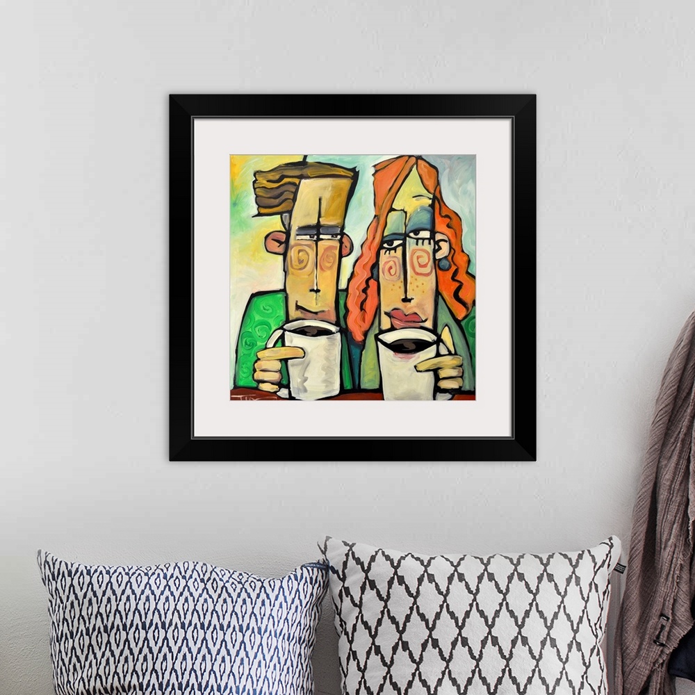 A bohemian room featuring Square painting of two cartoon like figures enjoying mugs of coffee.