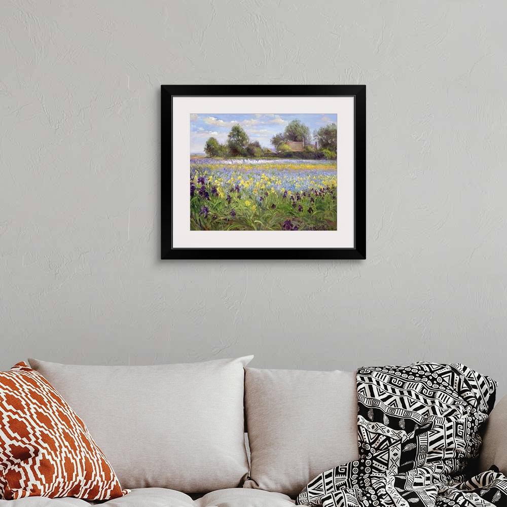 A bohemian room featuring Painting on canvas of a field of wildflowers with a house and trees in the distance.