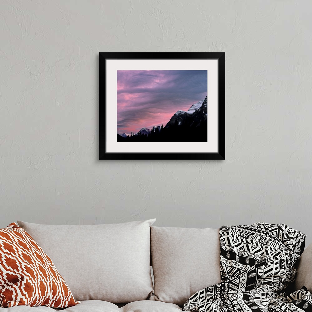 A bohemian room featuring Canada, Alberta, Rocky Mountains. The setting sun colors the clouds above the Canadian Rockies, A...