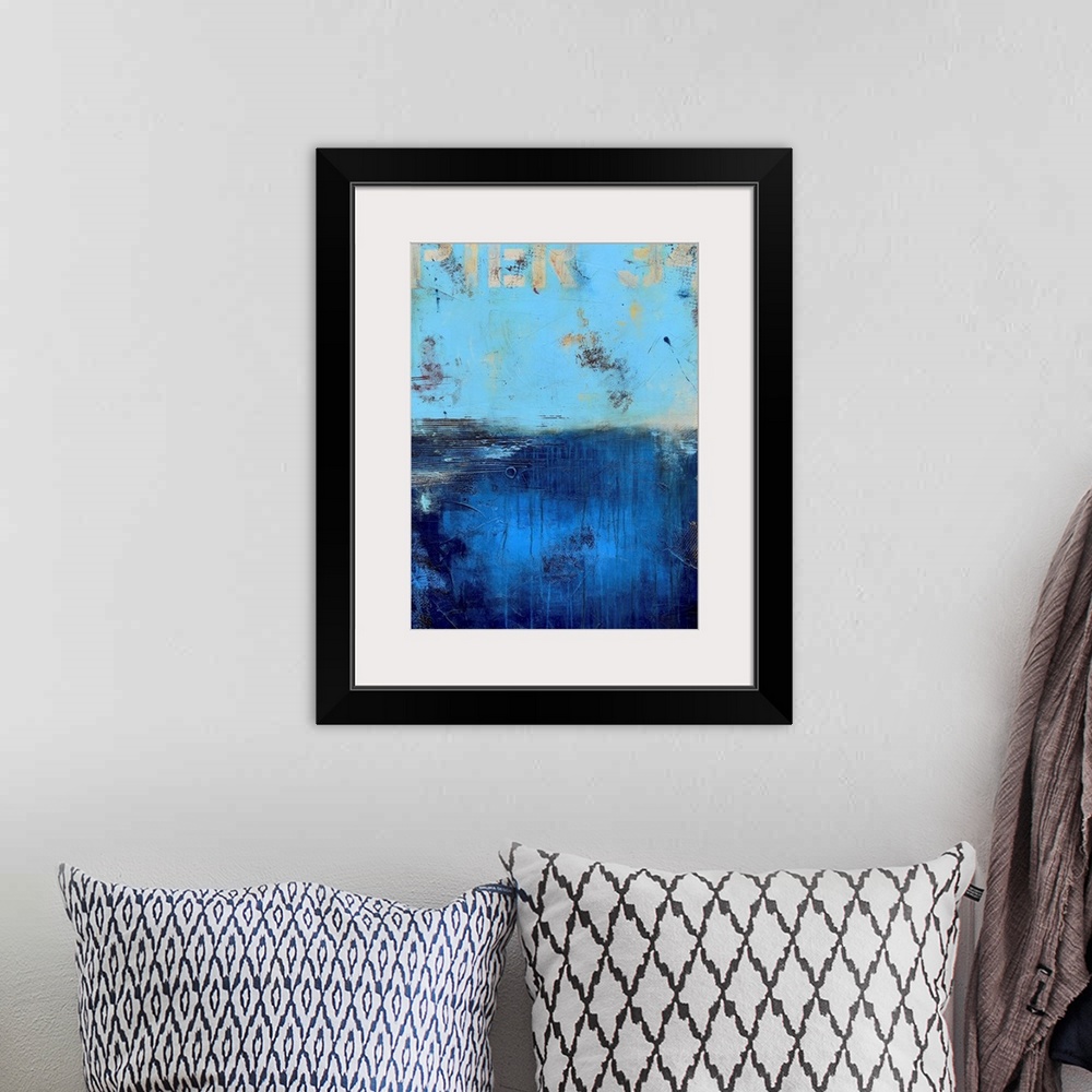 A bohemian room featuring A contemporary abstract painting using a light blue on the top portion of the image and a dark bl...