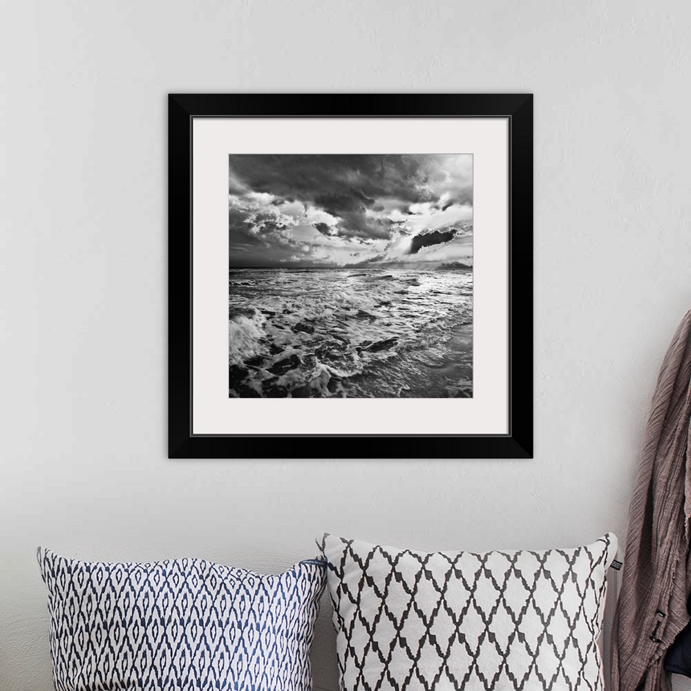 A bohemian room featuring A black and white image of the sea with crashing waves on the beach.