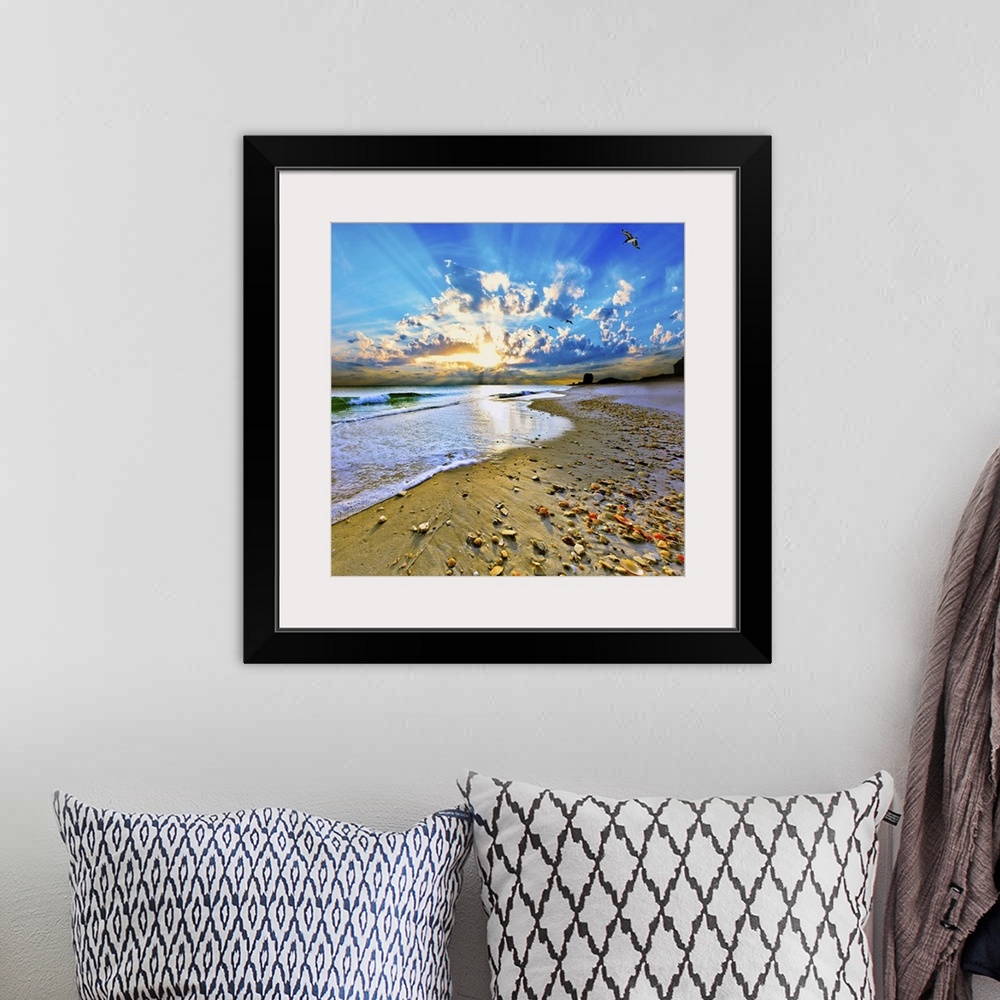 A bohemian room featuring A sandy shell covered shore before sun rays bursting out of a bright blue sunset. A very tranquil...