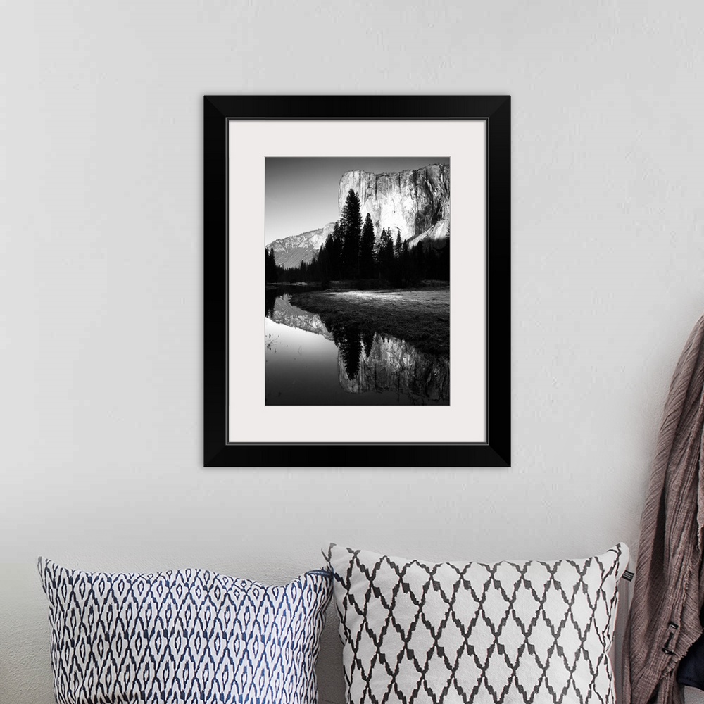A bohemian room featuring Black and white photo of a cliffside behind dark trees in Yosemite.