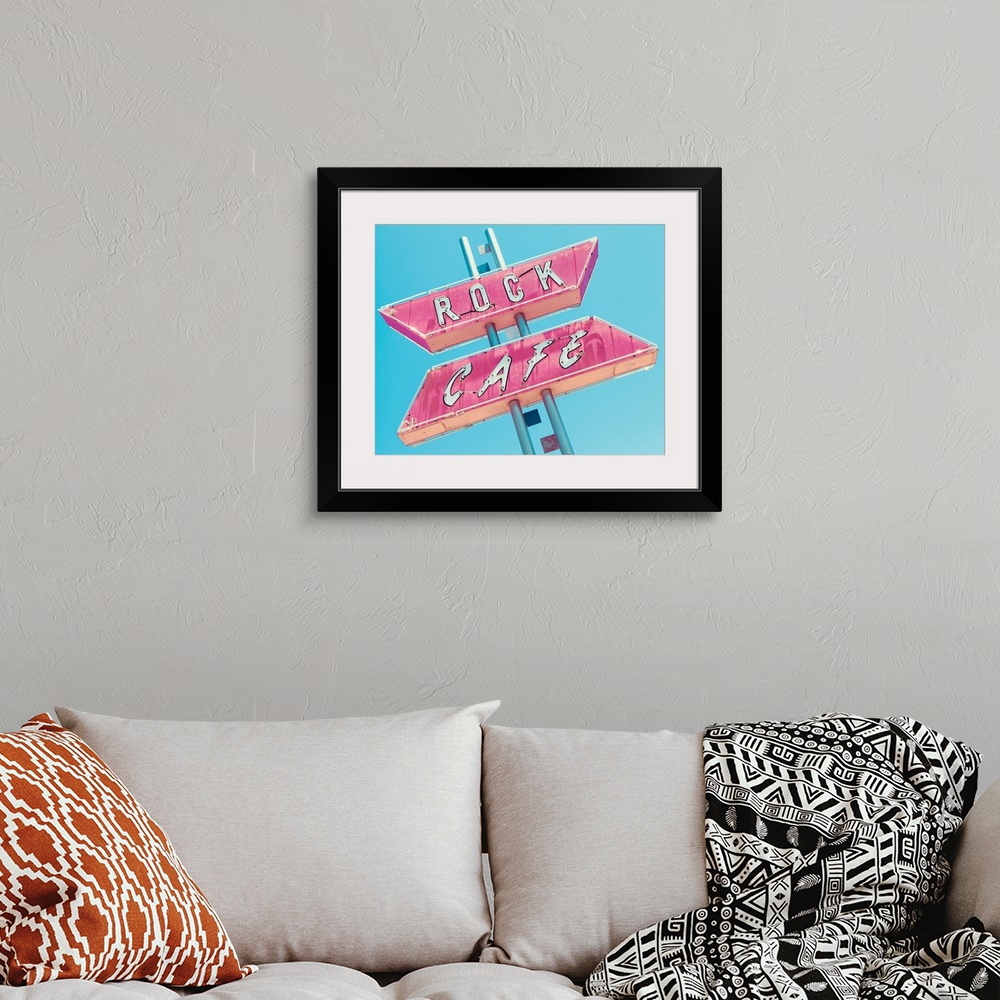 A bohemian room featuring Photograph of a retro pink and white 'Rock Cafe' light up sign on a blue sky background.