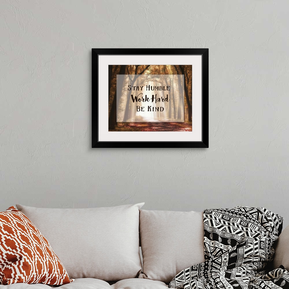 A bohemian room featuring A photograph of a pathway in the autumn woods with an inspirational quote overlay.