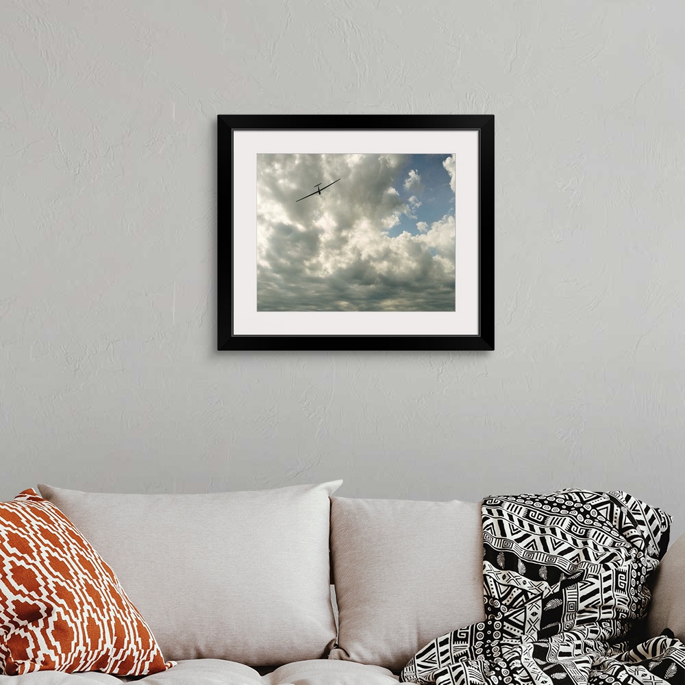 A bohemian room featuring Glider in flight against cloudy sky, low angle view