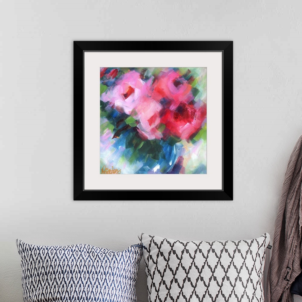 A bohemian room featuring A square abstract painting of bright pink flowers.