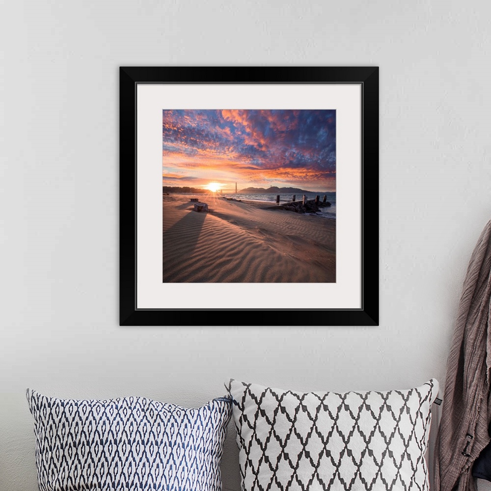 A bohemian room featuring A square photograph of a beach with the golden gate bridge in the background at sunset.
