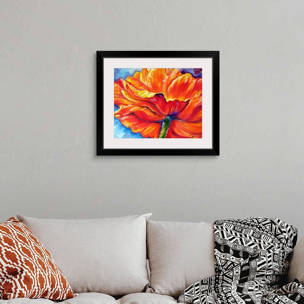 A bohemian room featuring Contemporary painting of an orange, red, and yellow poppy flower on a blue a toned background.