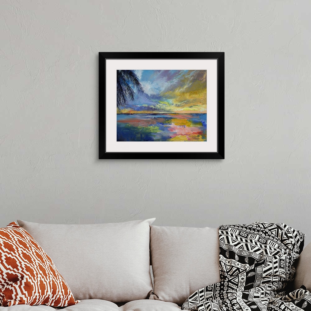 A bohemian room featuring Painting of ocean under a bright colorful sky at dusk with huge palm leaf hanging from above.